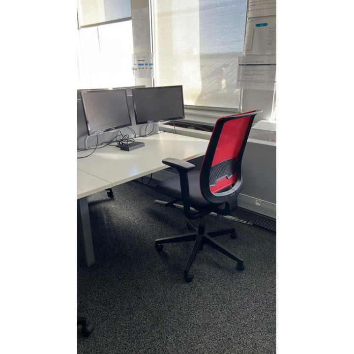 Fauteuil de bureau avec dossier en résille rouge et assise en tissu noir sur piètement en étoile